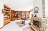 Wohnzimmer mit Bibliothek und Kamin